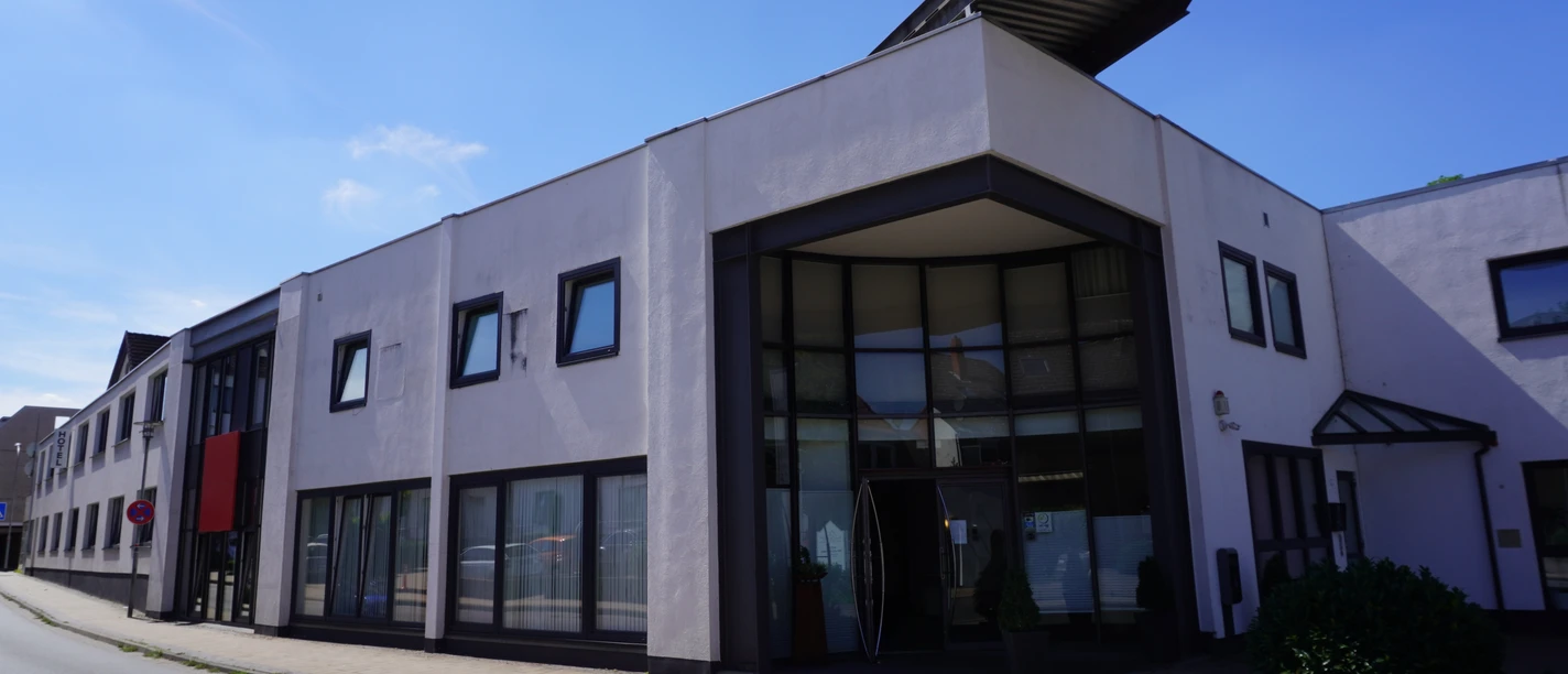 Thöles Hotel (2).JPG Modernes Hotelgebäude mit großflächigen Fenstern und einem winkeligen Eingangsbereich an der Straße.