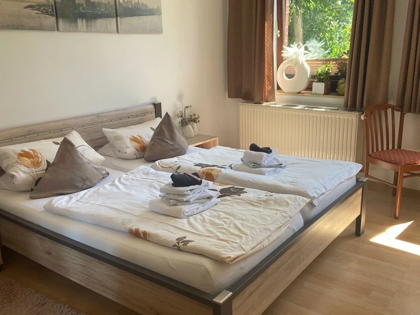 Inviting guest room with double bed, natural light, tasteful decoration and wooden floor.