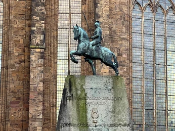 Reiterstatue auf Sockel vor historischem Gebäude, ehrt Gefallene des Ulanenregiments in Verden.