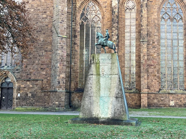 Ulanendenkmal Verden Das Ulanendenkmal Verden zeigt eine Reiterstatue aus Bronze vor der historischen Kirche in Verden.