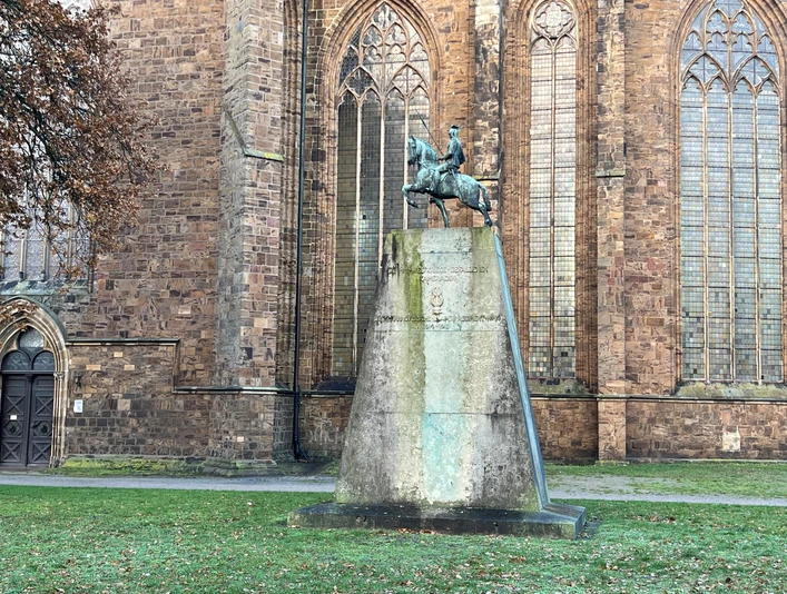 Ulanendenkmal Verden Das Ulanendenkmal Verden zeigt eine Reiterstatue aus Bronze vor der historischen Kirche in Verden.
