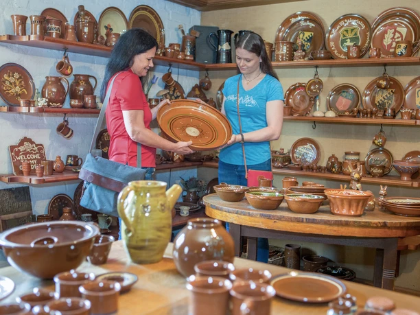 Traditionstöpferei in Hagen a.T.W. Zwei Frauen begutachten handgefertigte Keramikteller in einem Töpferladen.