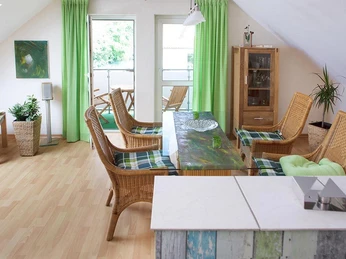 Nieheim-web-FW-Moeller-Merlsheim-04.jpg Eine freundlich eingerichtete Dachwohnung mit Essbereich und Zugang zum Balkon, umgeben von Grünpflanzen.