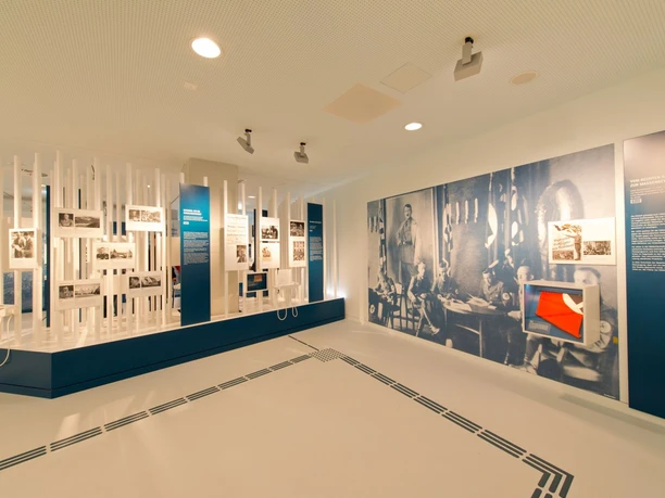 NS-Dokumentation Vogelsang IP Weißer Museumsraum mit einem großen Wandbild und Ausstellungen.