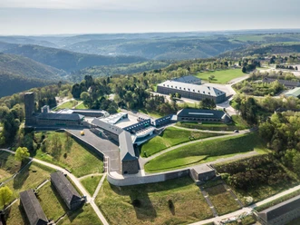 Vogelsang IP Festungsähnliches Gelände inmitten einer hügeligen Landschaft mit symmetrisch angeordneten Gebäuden und gepflegten Grünflächen.