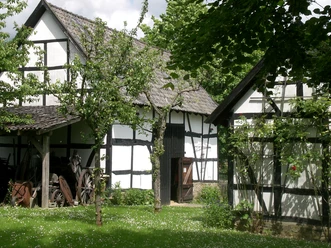 Bergisches Museum für Bergbau Handwerk & Gewerbe Fachwerkhäuser in grüner Umgebung mit alten landwirtschaftlichen Gerätschaften im Freilichtmuseum.