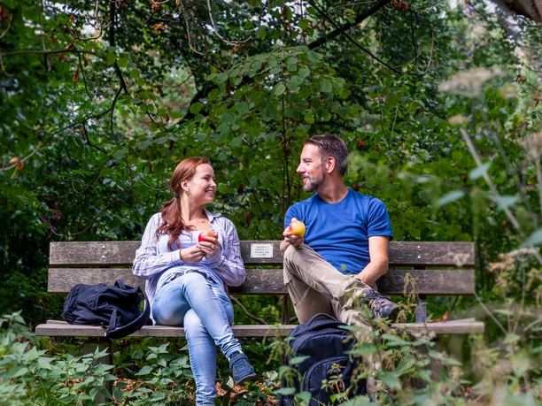Arboretum Burgholz Zwei Personen sitzen auf einer Bank im Wald