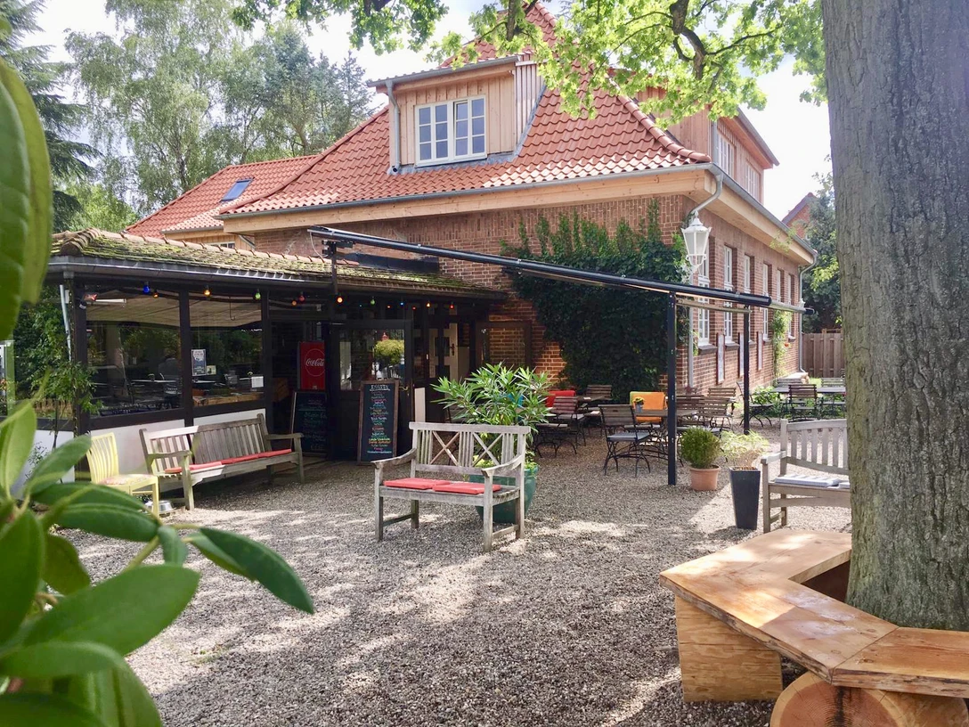 Eiscafé Bäk.jpg Blick vom Innenhof auf Sitzgelegenheiten vor dem Haus mit Tischen und Stühlen