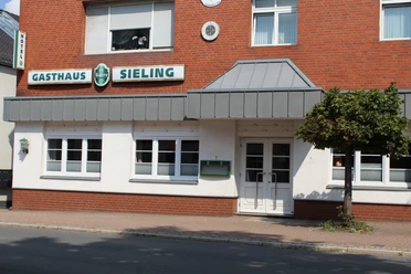 Hotel Sieling Das Hotel Sieling präsentiert eine schlichte Backsteinfassade mit typischen Fensterreihen.