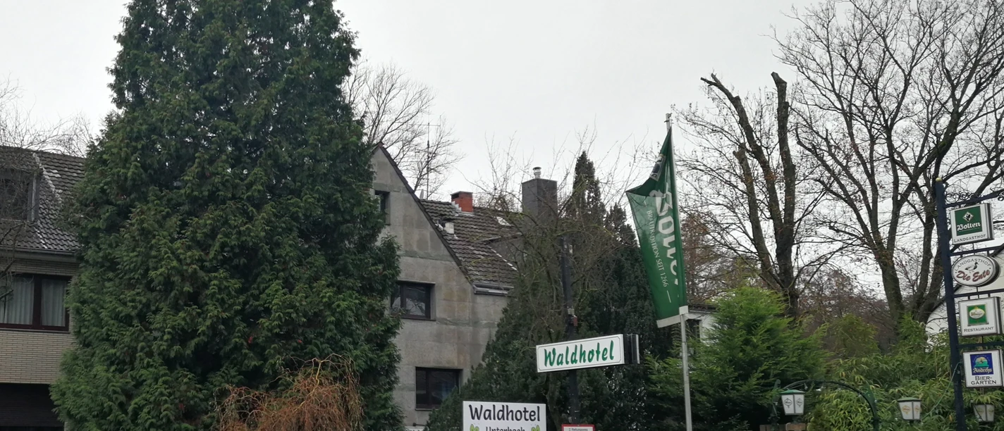Waldhotel Unterbach nahe Erkrath Waldhotel Unterbach nahe Erkrath mit grüner Fassade, hohen Bäumen und einem einladenden Eingangsbereich.