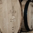 FARO Whisky Destillery_Whiskyfass.jpg Ein großes Holzfass mit der Aufschrift ‚FARO‘ steht in einem Lagerraum.