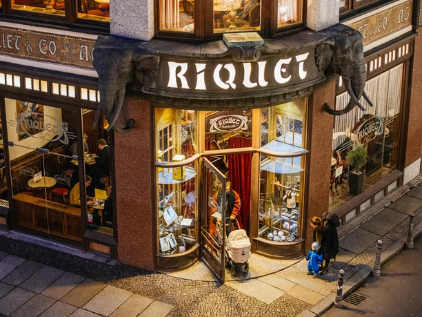 Pohled shora na vchod do kavárny Riquet a dvě sloní hlavy nade dveřmi, kultura kaváren, gastronomie, architektura