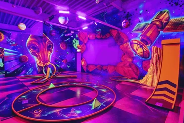 Im Blacklight District in Bispingen leuchten Planeten und futuristische Designs in Neonfarben an der Wand. Eine intergalaktische Atmosphäre lädt dazu ein, kreativ zu werden.