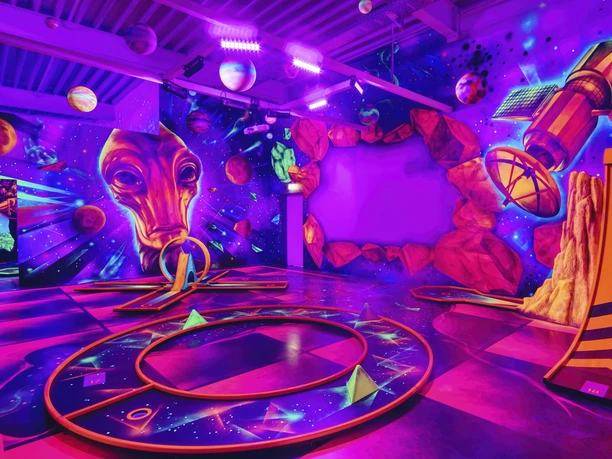 Blacklight_District_foto_ccbysa_foto©adventure-district.jpeg Im Blacklight District in Bispingen leuchten Planeten und futuristische Designs in Neonfarben an der Wand. Eine intergalaktische Atmosphäre lädt dazu ein, kreativ zu werden.