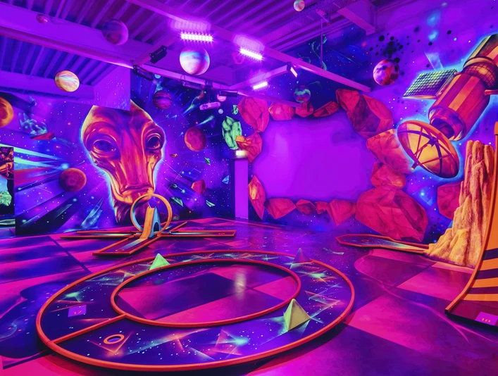 Blacklight_District_foto_ccbysa_foto©adventure-district.jpeg Im Blacklight District in Bispingen leuchten Planeten und futuristische Designs in Neonfarben an der Wand. Eine intergalaktische Atmosphäre lädt dazu ein, kreativ zu werden.