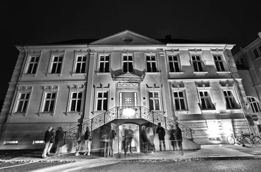JazzClub.jpg Historisches Gebäude mit elegantem Eingangsbereich, in Schwarz-Weiß gehalten, Menschen davor.