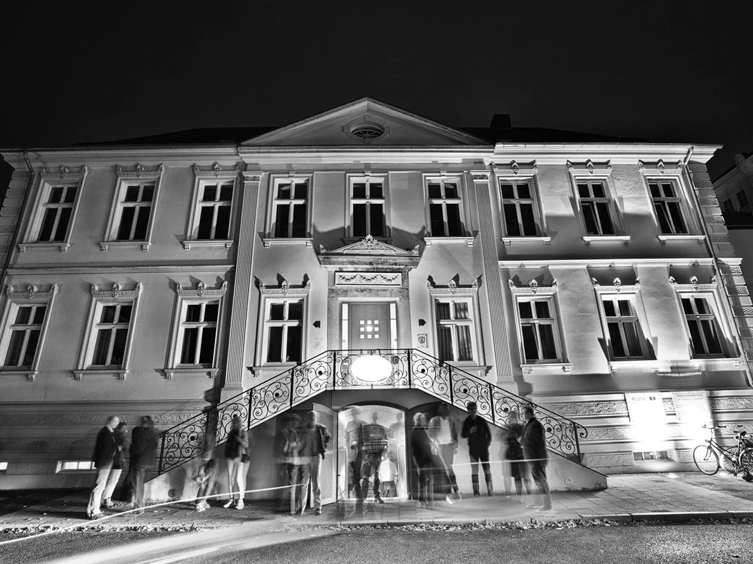 JazzClub.jpg Historisches Gebäude mit elegantem Eingangsbereich, in Schwarz-Weiß gehalten, Menschen davor.