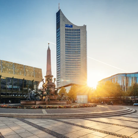 View of the Gewandhaus in Leipzig, the Mendebrunnen fountain and the City Tower on Augustusplatz during sunset, sights, music, culture - presented by Leipzig Convention Bureau