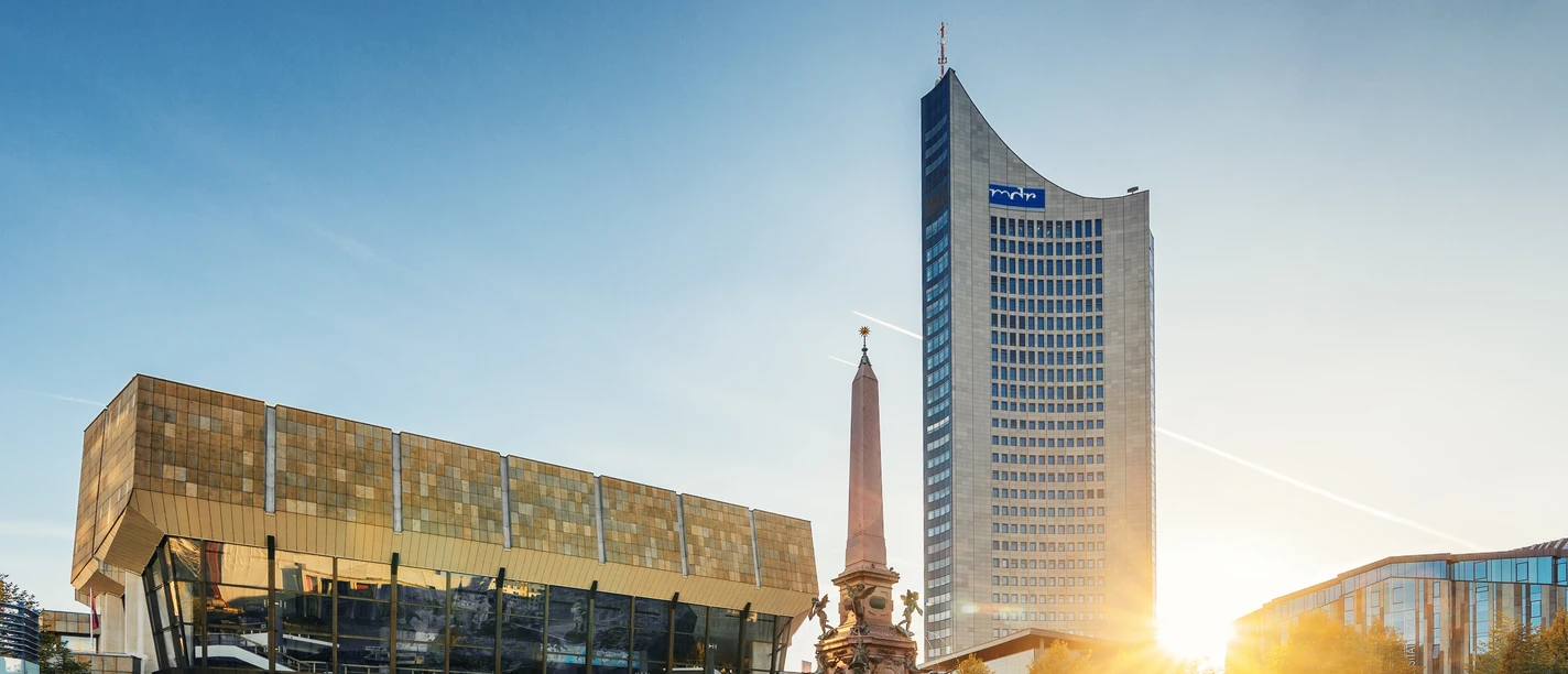Pohled na Gewandhaus v Lipsku, Mendovu fontánu a mrakodrap City na náměstí Augustusplatz při západu slunce, památky, hudba, kultura – představuje Leipzig Convention Bureau