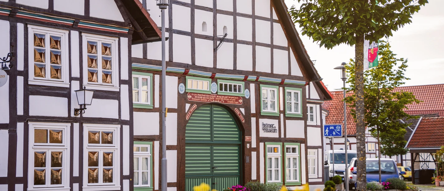 Fachwerkgebäude mit grünem Holztor des Heimatmuseums Lügde in städtischer Umgebung.
