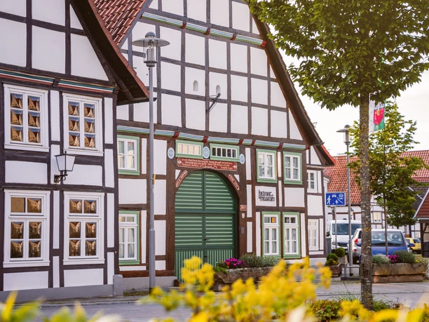 Fachwerkgebäude mit grünem Holztor des Heimatmuseums Lügde in städtischer Umgebung.