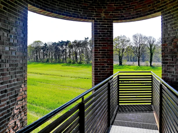 Landschaftsfenster Wemkendorf.JPG Blick durch einen Ziegelbogen auf grüne Wiesen und Bäume. Holzgeländer im Vordergrund.