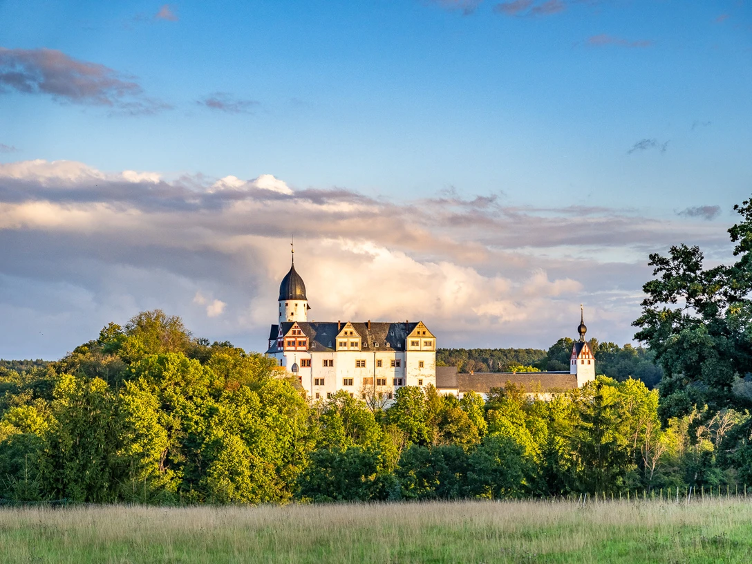 Schloss Rochsburg - Schlösser der Leipzig Region Das Schloss Rochsburg ragt über den Laubbäumen hervor und wird von der untergehenden Sonne in gold-gelbe Farben getaucht, leipzig Region, Ausflugsziel