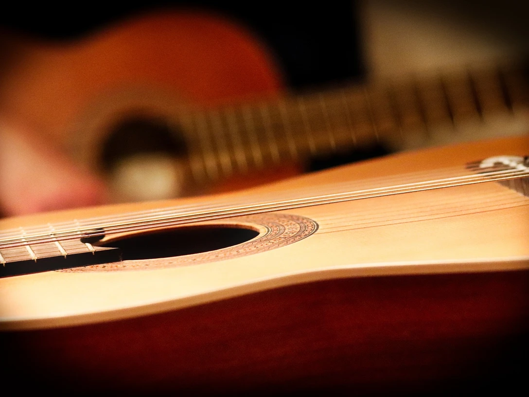 Gitarre Nahaufnahme einer klassischen Akustikgitarre, mit Fokus auf den Korpus und die Saiten.