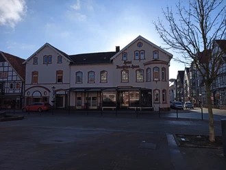Fassade des Hotels Deutsches Haus in einer modernen, zweigeschossigen Struktur mit Erker und Gauben.