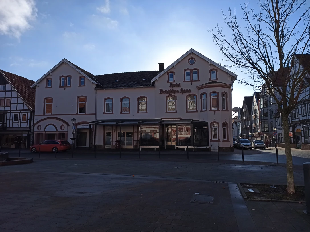 Hotel Deutsches Haus Fassade.jpg Fassade des Hotels Deutsches Haus in einer modernen, zweigeschossigen Struktur mit Erker und Gauben.