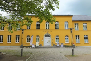 Rathaus Das Rathaus in Ratzeburg ist ein gelbes Gebäude mit weißen Fenstern und Tür. Davor ist ein Platz mit Gehwegen