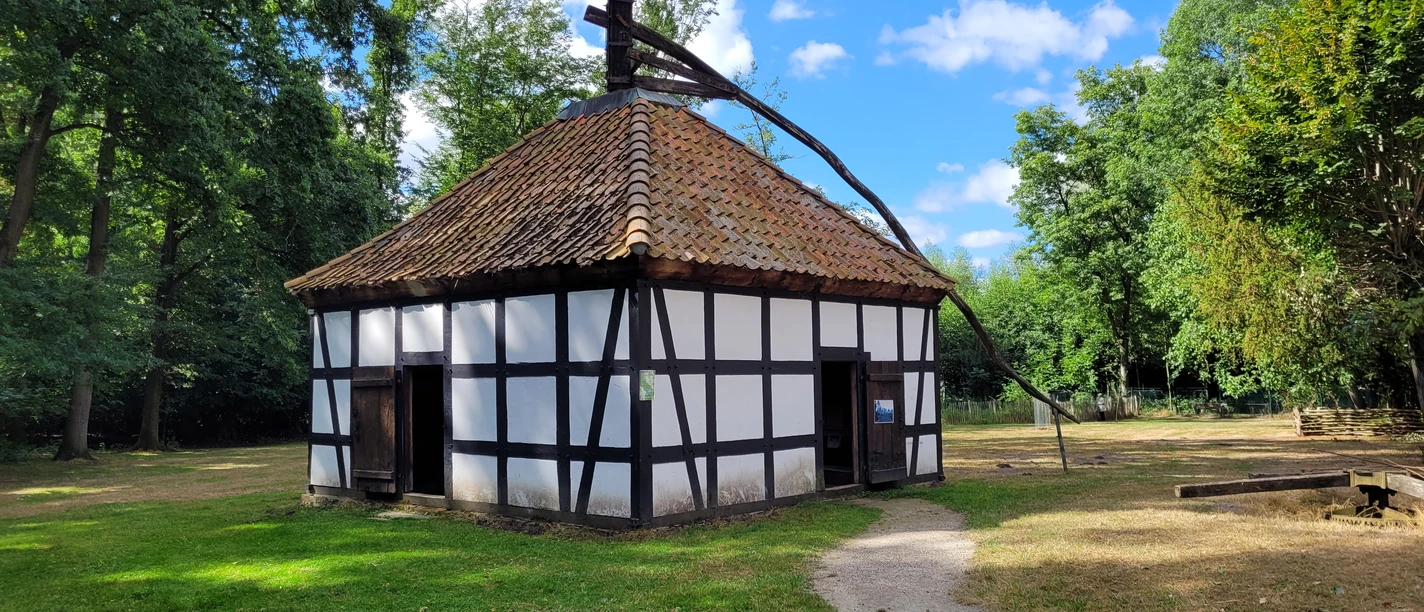 Weiß verputzte Fachwerkscheune Rossmühle Rahden mit ziegelgedecktem Dach mitten im Grünen.