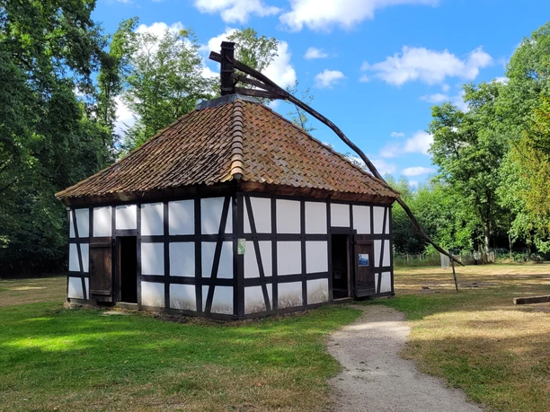 Weiß verputzte Fachwerkscheune Rossmühle Rahden mit ziegelgedecktem Dach mitten im Grünen.