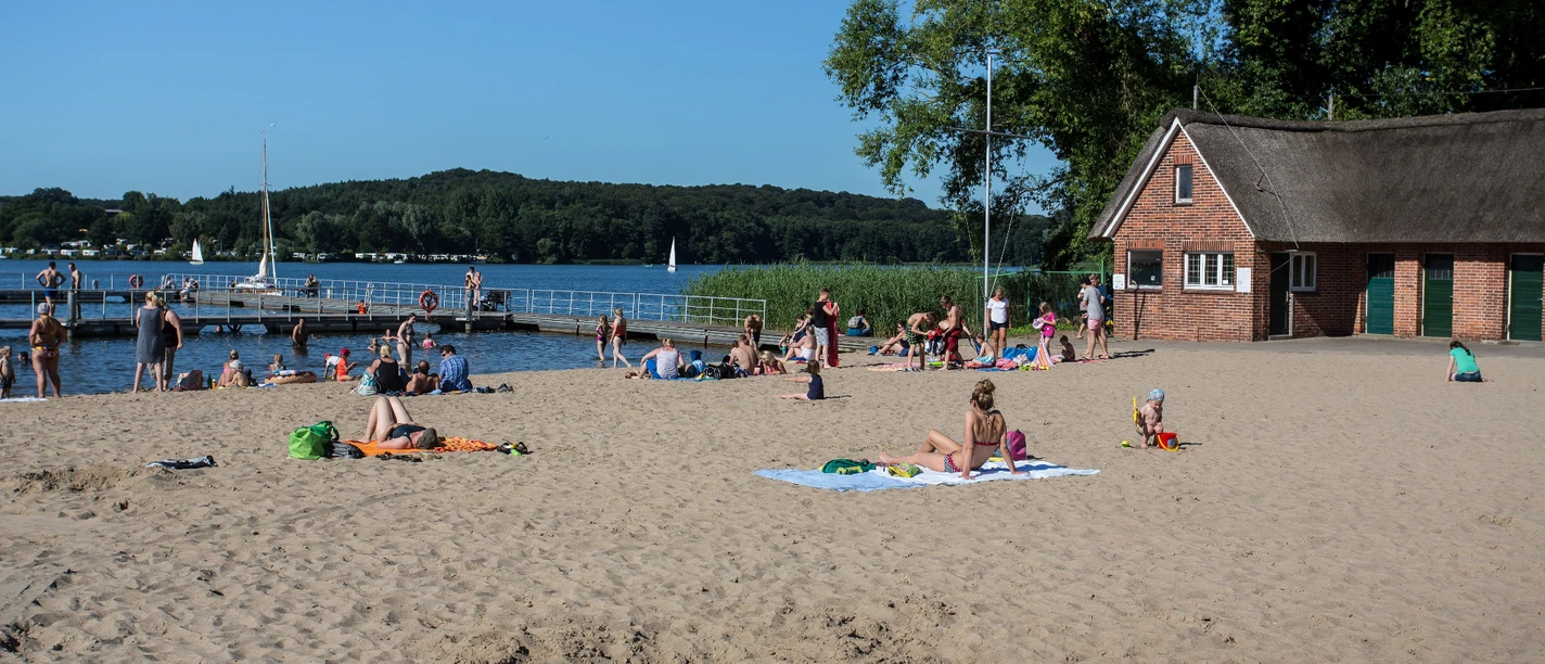 Strandbad_Schlosswiese_RZ_JensButz.jpg Strandbad mit vielen Besuchern, Steg ins Wasser und Badende im See