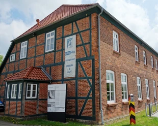 Grenzhus Schlagsdorf (J.Trebesius).JPG Fassade des Grenzhus Schlagsdorf aus Backstein mit einem historischen Grenzstein davor