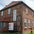 Grenzhus Schlagsdorf (J.Trebesius).JPG Fassade des Grenzhus Schlagsdorf aus Backstein mit einem historischen Grenzstein davor