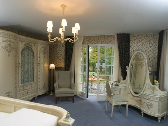 Elegant eingerichtetes Doppelzimmer mit klassischen Möbeln und Blick auf eine Terrasse im Garten.Elegantly furnished double room with classic furniture and a view of a terrace in the garden.Elegant indrettet dobbeltværelse med klassiske møbler og udsigt til en terrasse i haven.Elegant ingerichte tweepersoonskamer met klassieke meubels en uitzicht op een terras in de tuin.