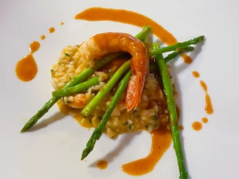 Reis mit Garnele_CCBYSA_Teutoburger Wald_Stadt Schloss Holte-Stukenbrock-26.jpg Garnelen-Risotto mit Spargel, kunstvoll angerichtet auf einem weißen Teller und garniert mit Sauce.