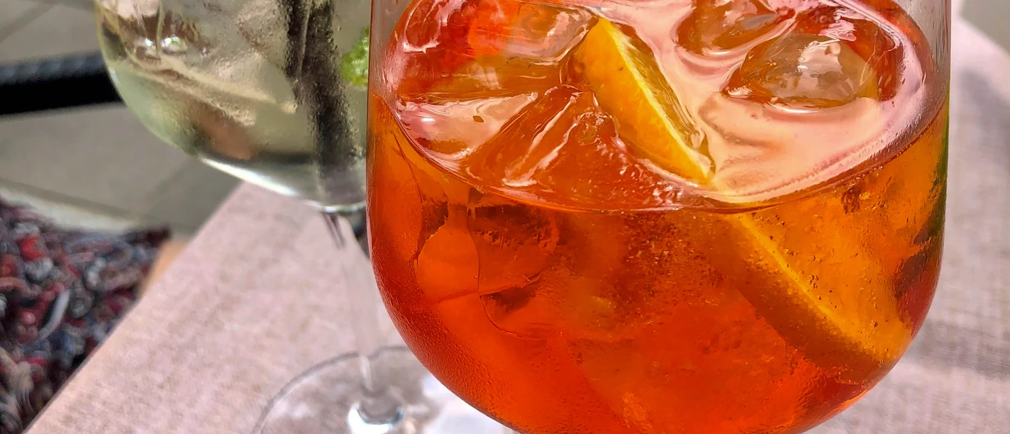 Essen_Drinks_SHS_CC-BY-SA_Teutoburger_Wald_Stadt_Schloss_Holte-Stukenbrock.jpg Zwei erfrischende Cocktails in großen Gläsern stehen auf einem Tisch, jeweils mit Eis und Garnitur.