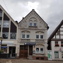Zum Scholli.jpg Restaurant Zum Scholli in historischem Gebäude mit verzierter Fassade und traditionellen Fenstern.