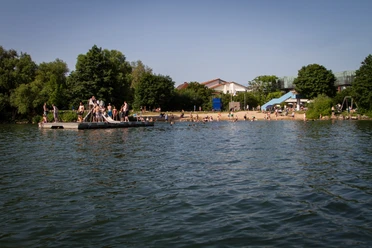 Badesetelle am Aqua Siwa - Küchensee, Jens Butz vewrwenden ok.jpg Badestelle Kurpark Aqua Siwa mit Strand, vielen Badegästen und einer Plattform im Wasser mit Rutsche