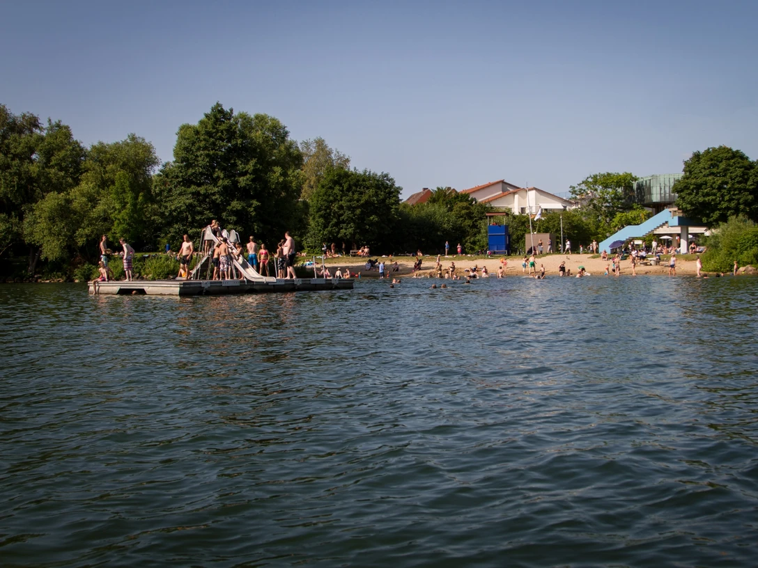 Badesetelle am Aqua Siwa - Küchensee, Jens Butz vewrwenden ok.jpg Badestelle Kurpark Aqua Siwa mit Strand, vielen Badegästen und einer Plattform im Wasser mit Rutsche