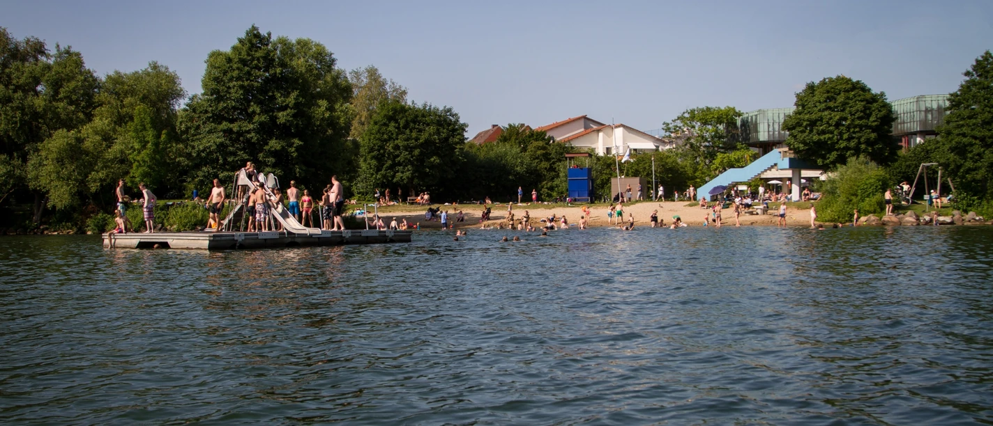 Badesetelle am Aqua Siwa - Küchensee, Jens Butz vewrwenden ok.jpg Badestelle Kurpark Aqua Siwa mit Strand, vielen Badegästen und einer Plattform im Wasser mit Rutsche