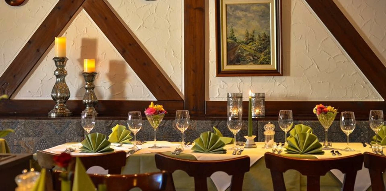 Einladendes Restaurant mit elegant gedeckten Tischen, Holzdetails und dezenter Beleuchtung.