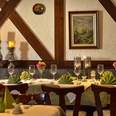Adria Restaurant Innen.jpg Einladendes Restaurant mit elegant gedeckten Tischen, Holzdetails und dezenter Beleuchtung.