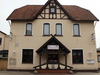 Ein zweistöckiges Gebäude im traditionellen Stil mit Fachwerkelementen und roten Dachziegeln.