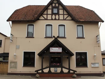 Parrmann Ein zweistöckiges Gebäude im traditionellen Stil mit Fachwerkelementen und roten Dachziegeln.