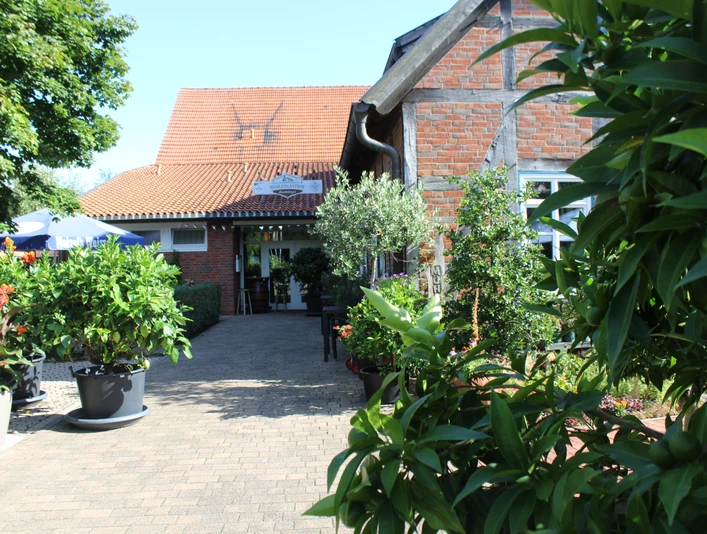 Mühlengasthof, Landesbergen Der Mühlengasthof in Landesbergen präsentiert einen Eingang mit Ziegelmauerwerk und üppiger Pflanzenpracht.The Mühlengasthof in Landesbergen presents an entrance with brickwork and lush plants.Mühlengasthof i Landesbergen har et indgangsparti med murværk og frodig plantepragt.Het Mühlengasthof in Landesbergen presenteert een entree met metselwerk en weelderige plantenpracht.