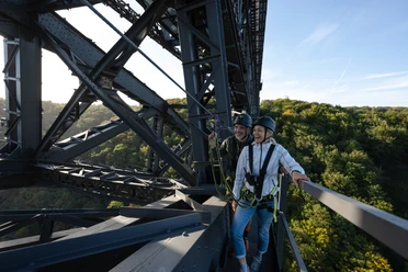 Brückensteig Zwei Personen in Kletterausrüstung auf einer Brücke