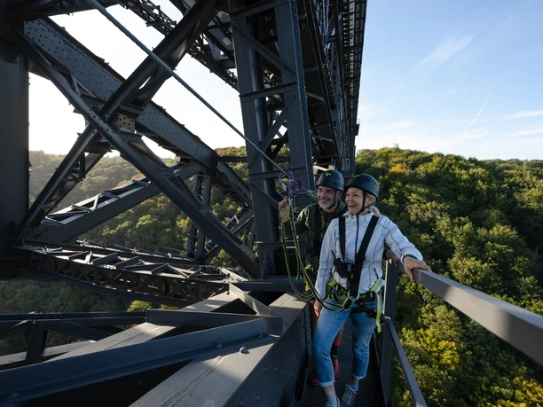 Brückensteig Zwei Personen in Kletterausrüstung auf einer Brücke